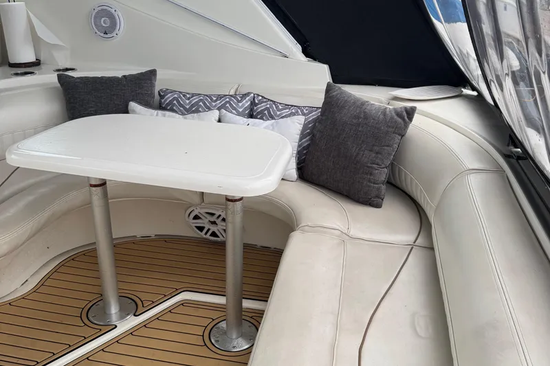 Slide: The Image of Interior of 2000 Cruisers Yachts 3870 Express with cushioned seating and table. - 3