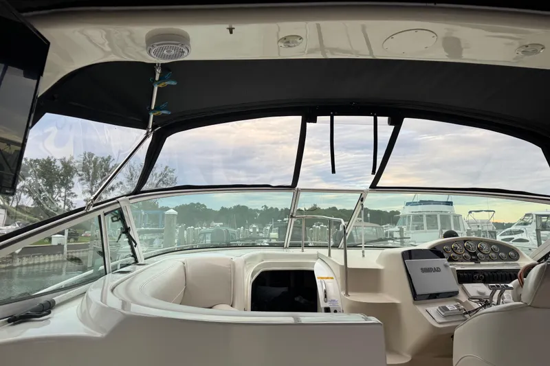 Slide: The Image of Interior view of 2000 Cruisers Yachts 3870 Express cockpit with dashboard and marina background. - 5
