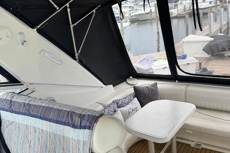 Slide: The Image of Interior of 2000 Cruisers Yachts 3870 Express with cozy seating and table, dockside view. - 7