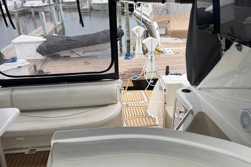 Slide: The Image of 2000 Cruisers Yachts 3870 Express interior with dock view, featuring seating and deck area. - 8