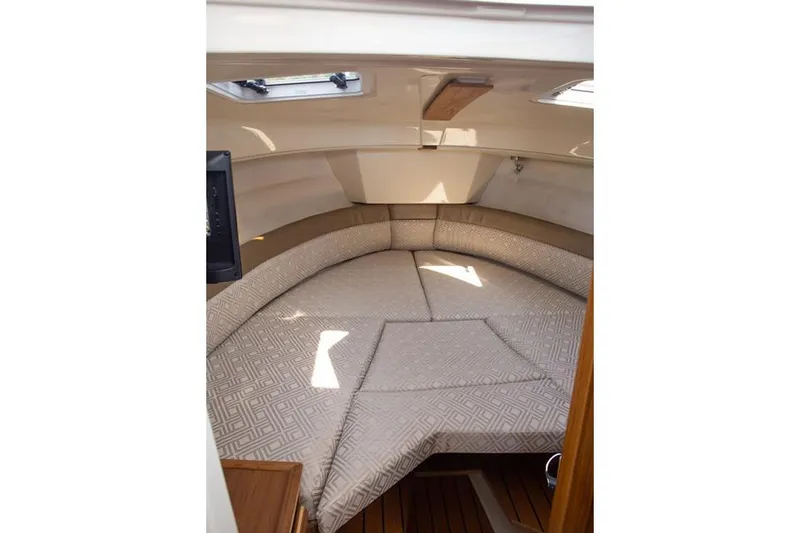 Slide: The Image of Manufacturer Provided Image: 2025 Ranger Tugs R-25 interior cabin with cushioned seating and natural light. - 10