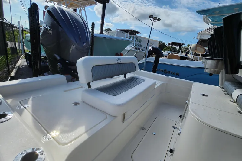 Slide: The Image of 2026 ShearWater 25 LTD boat interior with seating and motor, displayed outdoors. - 3