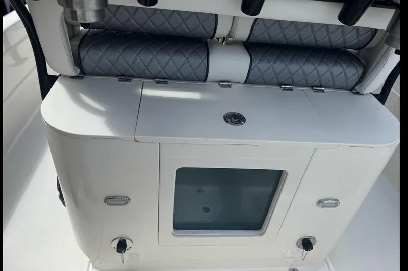 Slide: The Image of 2026 ShearWater 25 LTD boat interior with cushioned seating and storage compartment. - 5