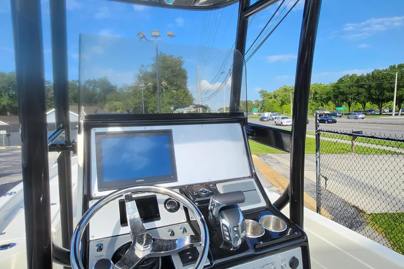 Slide: The Image of 2026 ShearWater 25 LTD boat dashboard with steering wheel and navigation screen. - 7