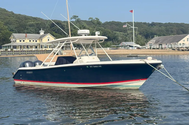The Image of 2011 Pursuit S 280 Sport boat anchored near a scenic waterfront. - 0
