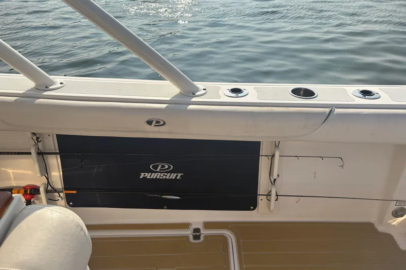 Slide: The Image of 2011 Pursuit S 280 Sport boat interior with rod holders and water view. - 12