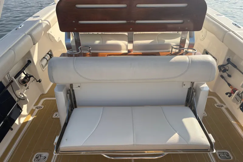 Slide: The Image of 2011 Pursuit S 280 Sport boat interior with cushioned seating and fishing rod holders. - 14