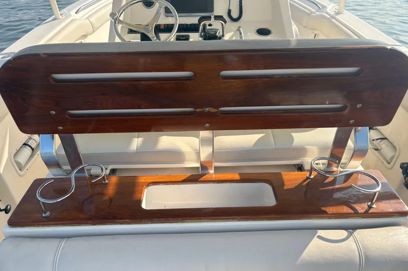 Slide: The Image of 2011 Pursuit S 280 Sport boat interior with wooden seating and cup holders. - 15