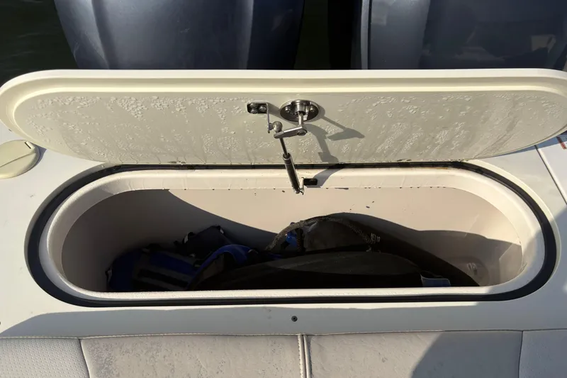 Slide: The Image of Open storage compartment on 2011 Pursuit S 280 Sport boat, showing interior contents. - 17