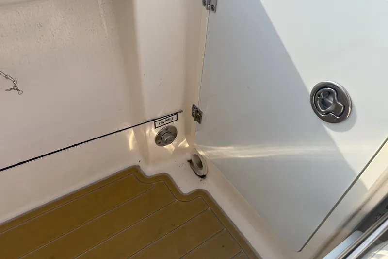 Slide: The Image of 2011 Pursuit S 280 Sport boat interior with raw water access and storage compartment. - 19