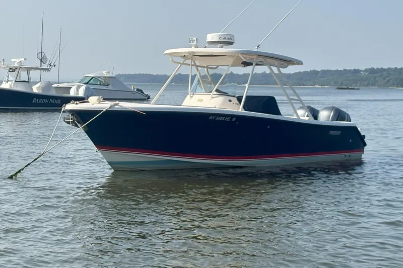 Slide: The Image of 2011 Pursuit S 280 Sport boat anchored in calm waters. - 2