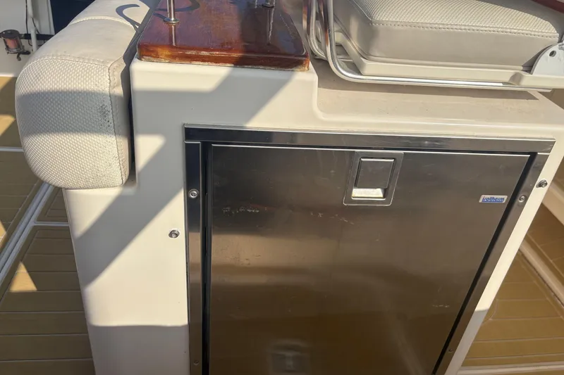 Slide: The Image of 2011 Pursuit S 280 Sport boat interior with stainless steel cabinet and cushioned seating. - 27