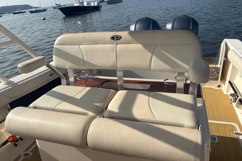 Slide: The Image of 2011 Pursuit S 280 Sport boat with beige seating, docked on calm water. - 30