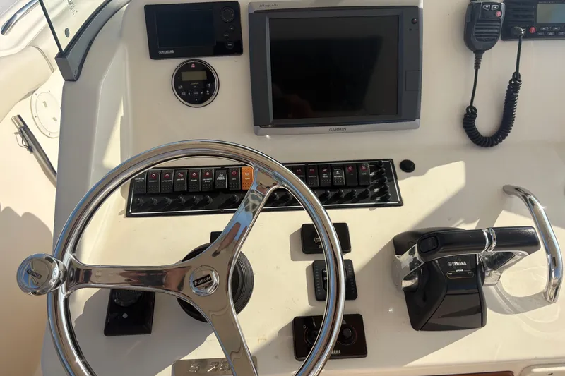 Slide: The Image of Dashboard of a 2011 Pursuit S 280 Sport boat with steering wheel and controls. - 32