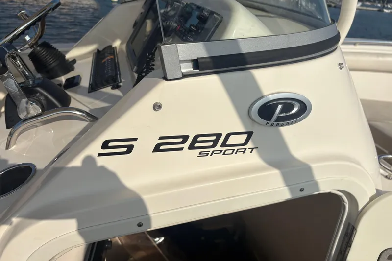 Slide: The Image of 2011 Pursuit S 280 Sport boat dashboard with logo and controls. - 34