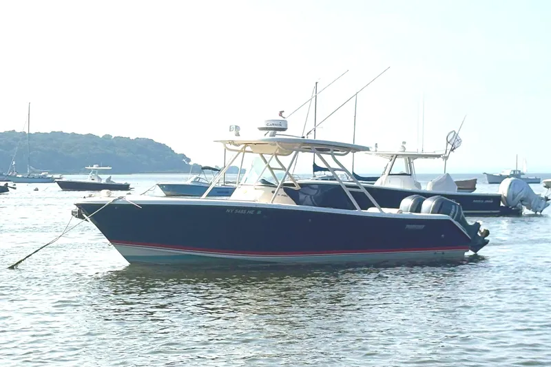 Slide: The Image of 2011 Pursuit S 280 Sport boat anchored in calm waters with other boats nearby. - 4