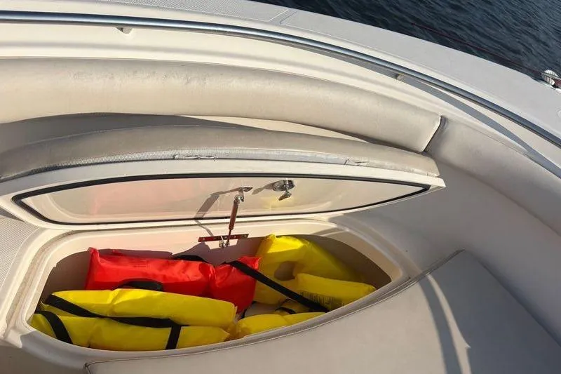 Slide: The Image of Storage compartment with life jackets on a 2011 Pursuit S 280 Sport boat. - 44