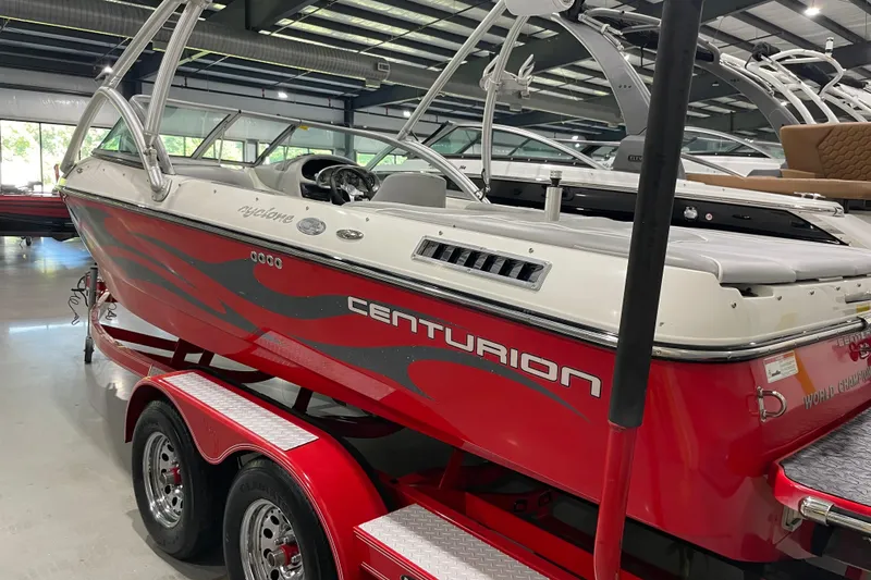 Slide: The Image of 2007 Centurion Cyclone C4 boat with red and white design on a trailer in a showroom. - 5