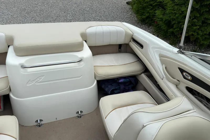 Slide: The Image of 1998 Sea Ray 190 Bow Rider interior with white seating and storage area. - 12