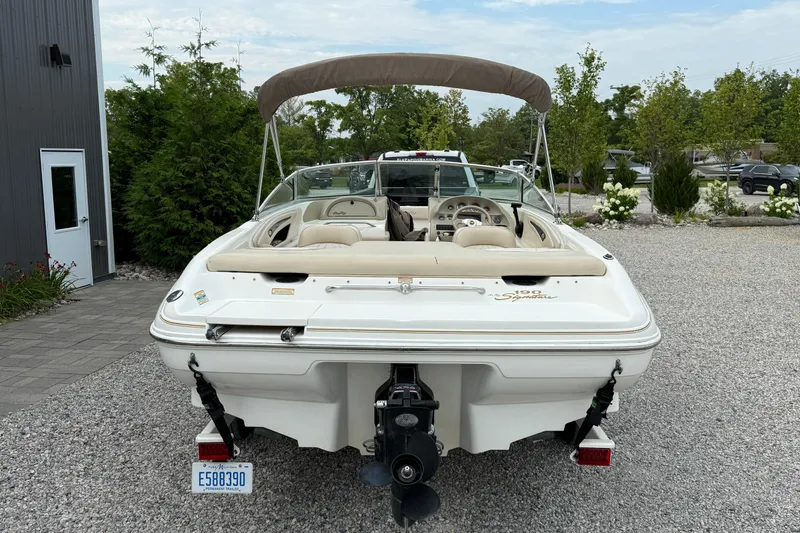 Slide: The Image of 1998 Sea Ray 190 Bow Rider boat with canopy, parked on gravel. - 3