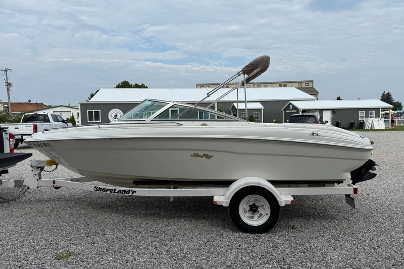 Slide: The Image of 1998 Sea Ray 190 Bow Rider boat on ShoreLand'r trailer, parked on gravel. - 6
