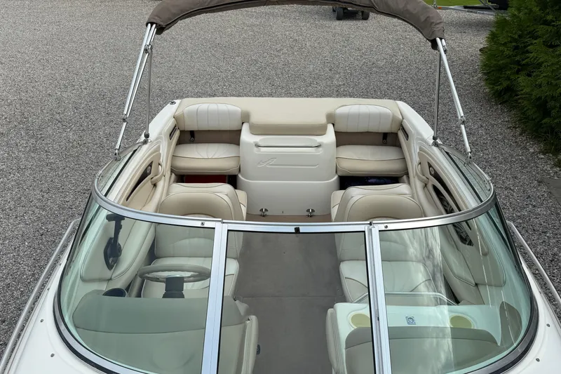 Slide: The Image of 1998 Sea Ray 190 Bow Rider boat with beige interior and windshield, parked on gravel. - 9