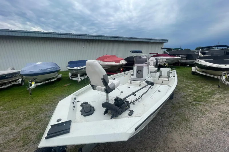 Slide: The Image of 2021 Crestliner 2000 Bay boat displayed outdoors with other covered boats. - 16