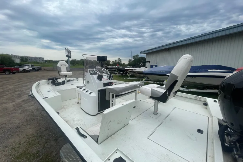 Slide: The Image of 2021 Crestliner 2000 Bay boat with seating and control console, parked outdoors. - 5