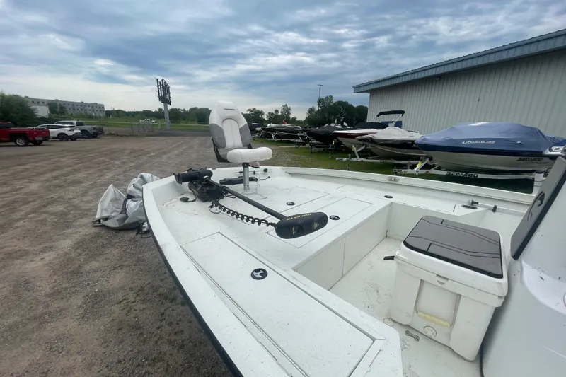 Slide: The Image of 2021 Crestliner 2000 Bay boat in outdoor storage, featuring a white deck and seating. - 6