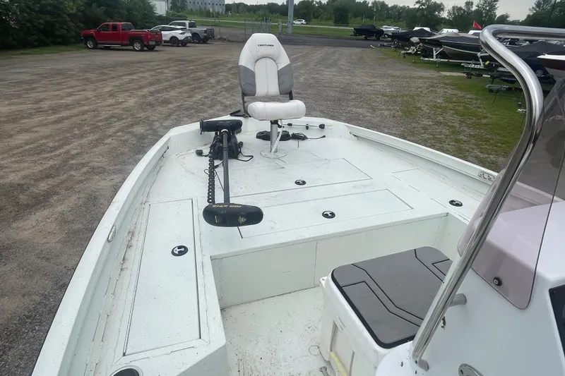 Slide: The Image of 2021 Crestliner 2000 Bay boat interior with seating and trolling motor in a parking area. - 7
