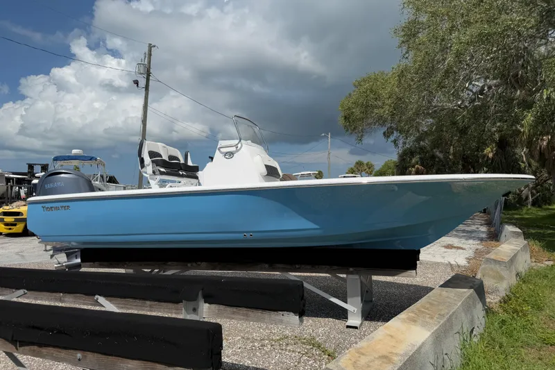 Slide: The Image of 2026 Tidewater 2110 Bay Max boat in blue, parked outdoors under cloudy sky. - 13
