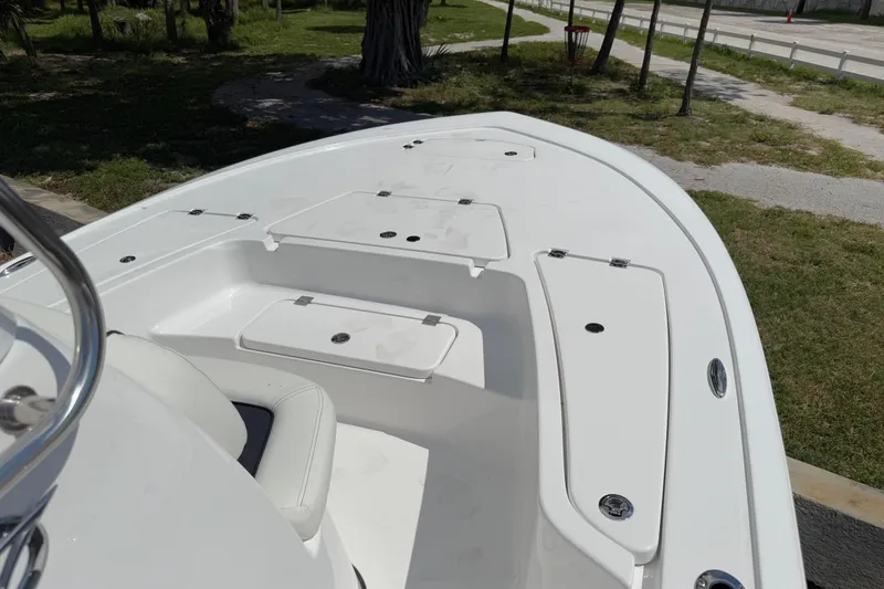 Slide: The Image of 2026 Tidewater 2110 Bay Max boat deck with storage compartments, parked on grassy area. - 5