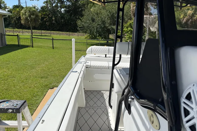 Slide: The Image of 2005 Apache 36CC boat interior with white seating, docked near a grassy yard. - 17