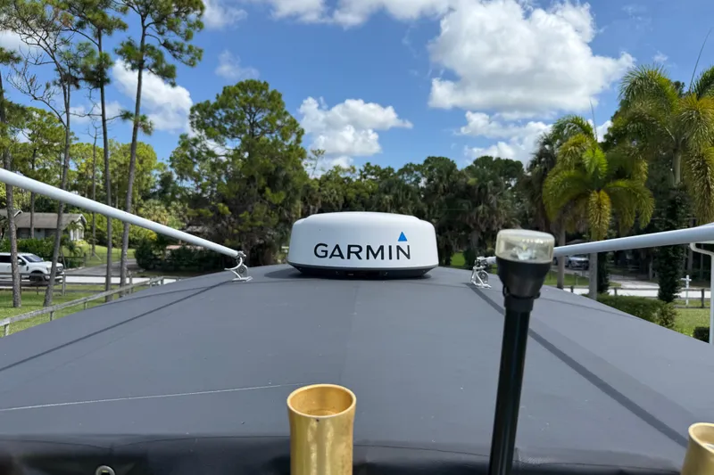 Slide: The Image of 2005 Apache 36CC boat with Garmin radar, surrounded by trees and blue sky. - 27
