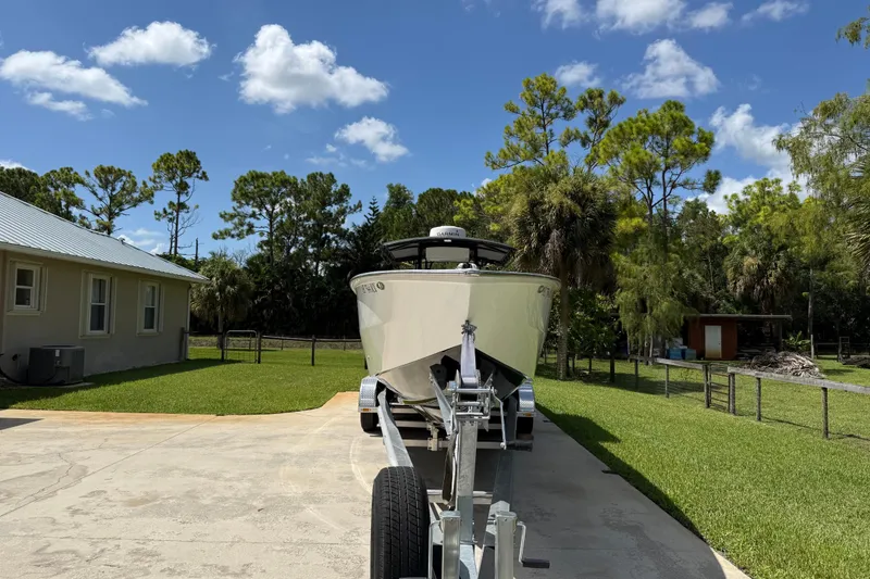 Slide: The Image of 2005 Apache 36CC boat on trailer in sunny driveway, surrounded by trees and house. - 5