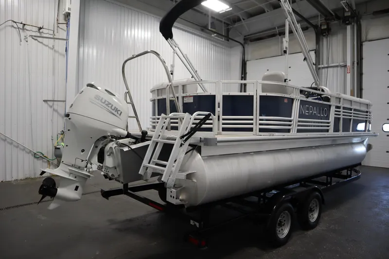 Slide: The Image of 2023 Nepallo 20 CW Pontoon boat with Suzuki outboard motor in a garage. - 4