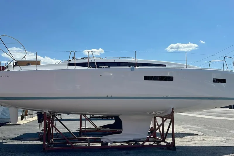 The Image of 2025 Jeanneau Sun Odyssey 380 sailboat on dry dock under clear blue sky. - 0