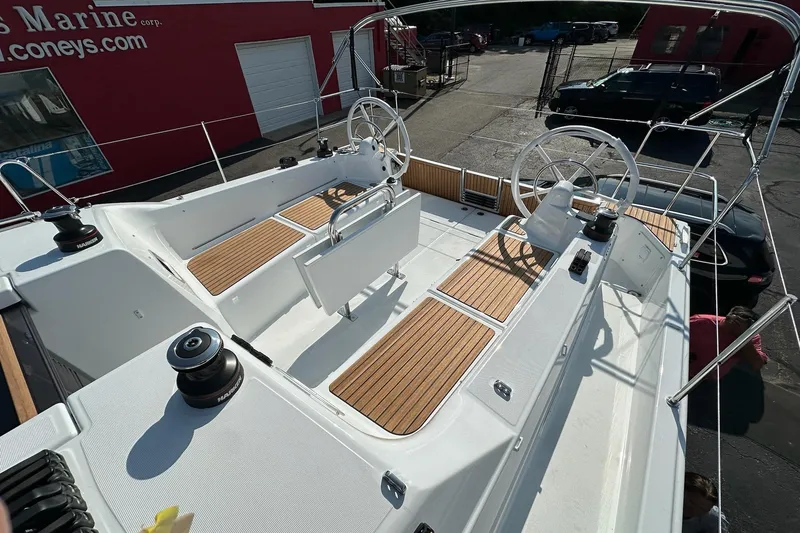 Slide: The Image of 2025 Jeanneau Sun Odyssey 380 sailboat cockpit with dual steering wheels and teak flooring. - 10