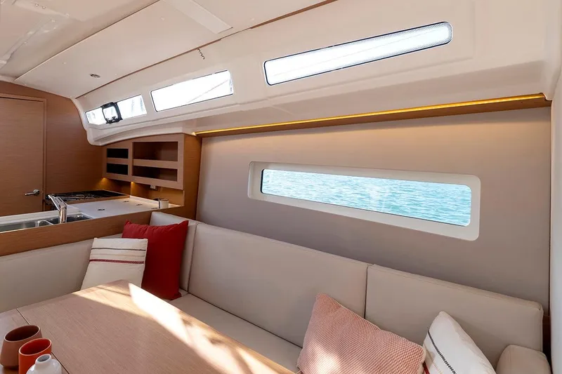 Slide: The Image of Interior of 2025 Jeanneau Sun Odyssey 380 yacht, featuring modern seating and ocean view. - 13