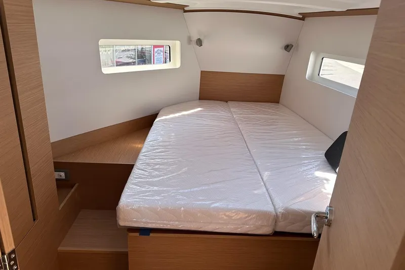 Slide: The Image of Interior cabin of 2025 Jeanneau Sun Odyssey 380 yacht, featuring a cozy bed and wooden finish. - 18