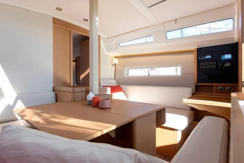 Slide: The Image of Interior of 2025 Jeanneau Sun Odyssey 380 yacht, featuring modern seating and navigation panel. - 20