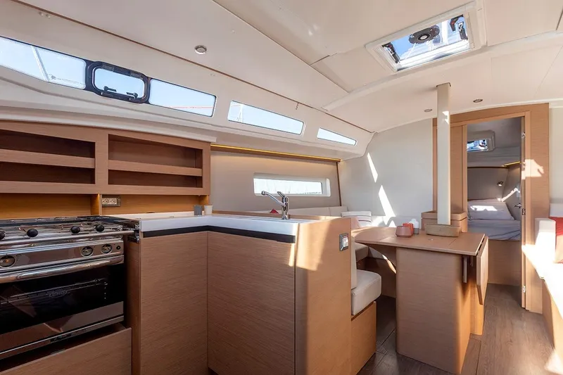 Slide: The Image of Modern interior of 2025 Jeanneau Sun Odyssey 380 yacht, featuring kitchen and dining area. - 22