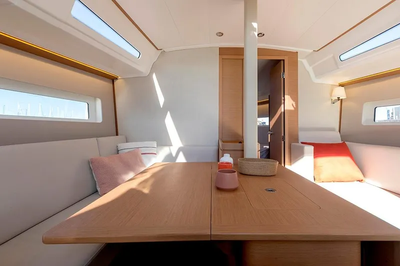 Slide: The Image of Interior of 2025 Jeanneau Sun Odyssey 380 yacht, featuring elegant seating and wooden table. - 23