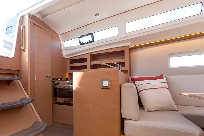 Slide: The Image of Interior of 2025 Jeanneau Sun Odyssey 380 yacht, featuring modern kitchen and cozy seating area. - 24