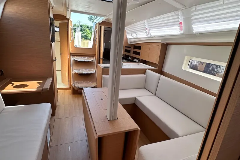 Slide: The Image of 2025 Jeanneau Sun Odyssey 380 interior with modern wood finish and white seating. - 27