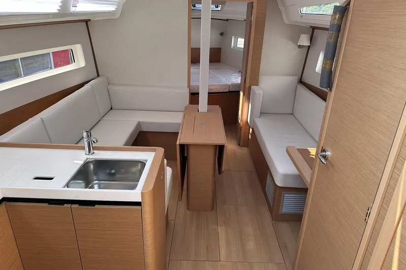 Slide: The Image of 2025 Jeanneau Sun Odyssey 380 interior with modern kitchen and cozy seating area. - 29