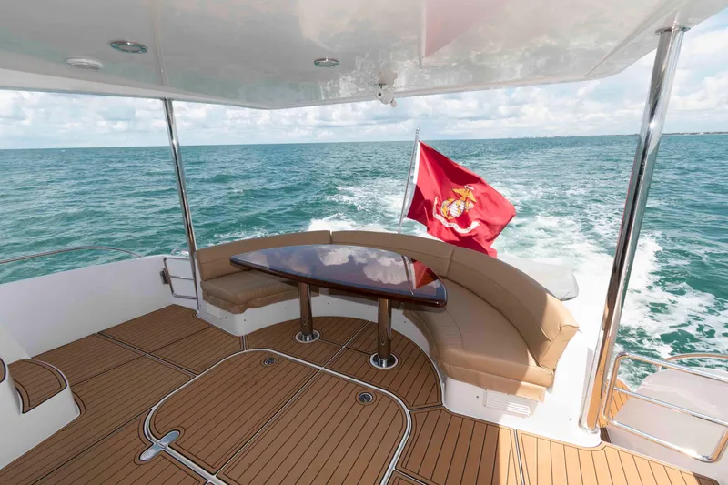 Slide: The Image of 2009 Hatteras 60 Motor Yacht deck with seating, table, and marine flag. - 15