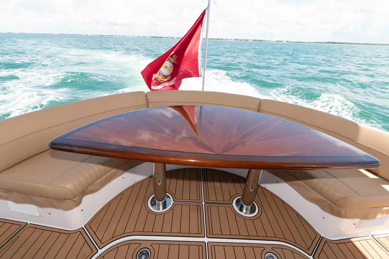 Slide: The Image of Luxury deck of 2009 Hatteras 60 Motor Yacht with elegant wood table and marine flag. - 16