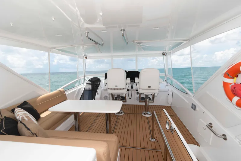 Slide: The Image of Luxurious 2009 Hatteras 60 Motor Yacht interior with ocean view, featuring seating and helm. - 17