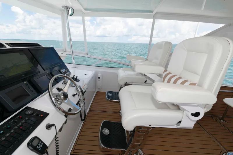 Slide: The Image of Helm of 2009 Hatteras 60 Motor Yacht with white captain chairs and navigation equipment. - 23